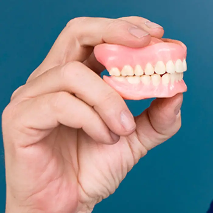 Full dentures held in a hand